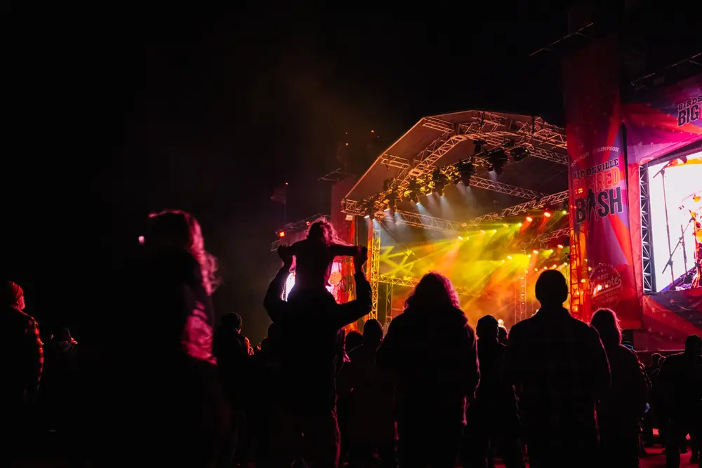 An artist on stage at the Big Red Bash with the dune behind
